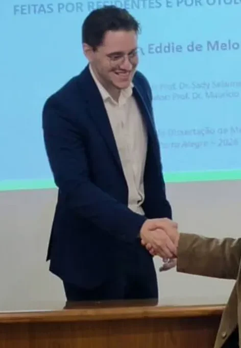 Dr. Caio Alves apertando a mão de um membro da banca na defesa da dissertação de mestrado